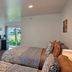 Pacific City Inn guest room with two beds, desk, TV, and sliding glass door to outdoor view