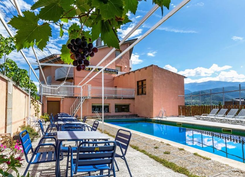 Hotel Restaurante La Glorieta in La Seu d'Urgell, outdoor pool with lounge chairs and mountain views