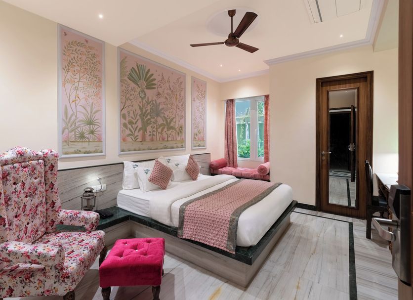 Hotel Panna Vilas Palace Udaipur room with floral armchairs, king bed, pink accents and wall art