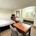 Budget Inn Northport room with two beds, TV, table and vanity sink in Northport