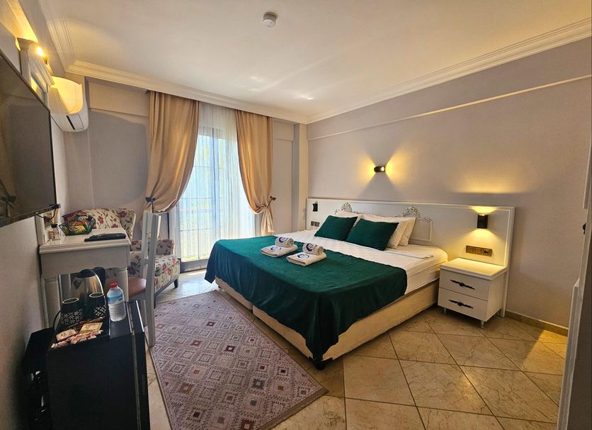B&B Boutique Hotel in Dalyan, Mugla: guest room with king bed, tiled floor, and balcony doors
