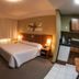 Tri Hotel Executive Caxias guest room in Caxias do Sul with a bed, bedside lamps and curtained window