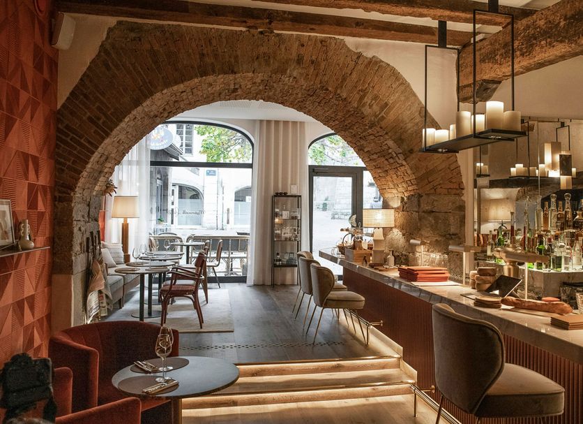 Petit Hôtel Confidentiel in Chambéry: arched stone interior with bar, seating, and dining area