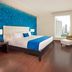 Ramada Plaza Panama Punta Pacifica room with king bed, city view, lounge chair and desk in Panama City