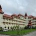 Mawlamyine Strand Hotel in Mawlamyine with red-roofed multiwing building and landscaped grounds