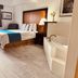 Travelodge by Wyndham Valleyfair Shakopee guest room with bed and in-room soaking tub