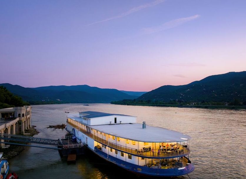 Aquamarina Hotel Visegrád in Budapest docked on the river at sunset with mountain views