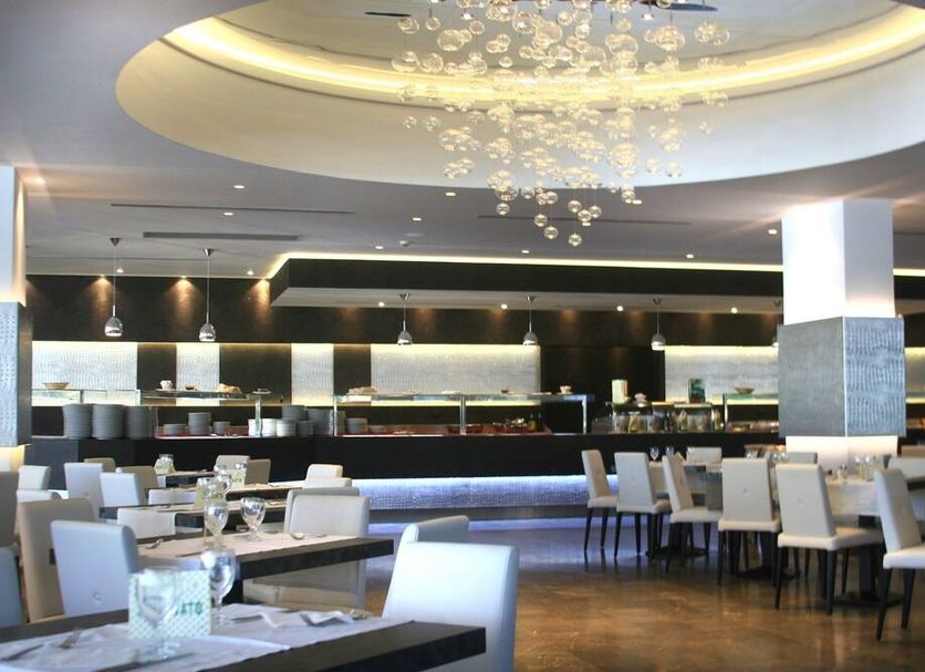 Hotel Santa Lucia Le Sabbie d'Oro restaurant interior in Cefalù with modern seating and chandelier