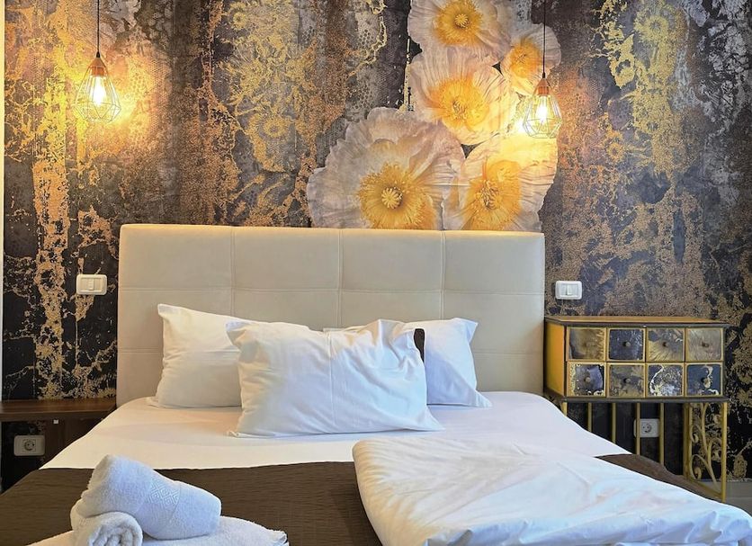 Decebal Residence Apartments Bucharest room with bed, floral wall mural and bedside table