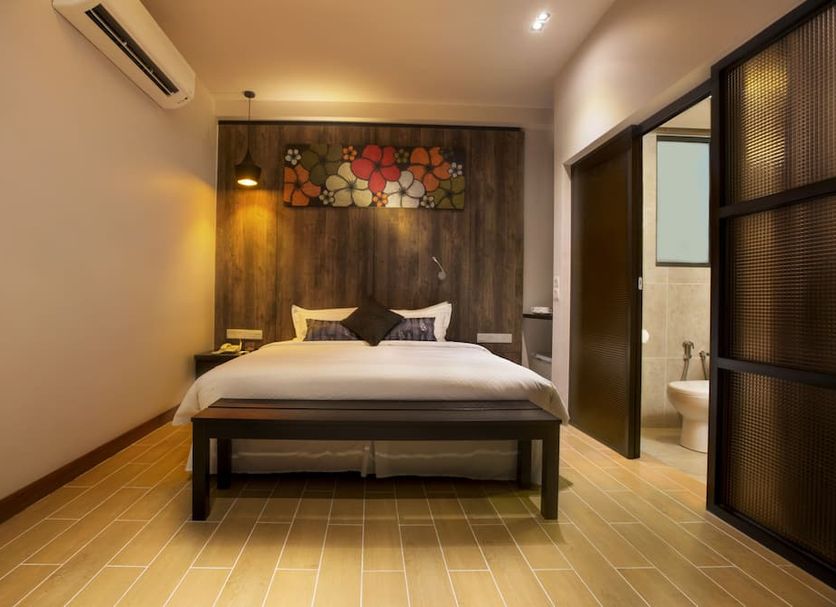 Hotel Twenty 8B in Kuala Lumpur guest room with king bed, wood accent wall, and adjoining bathroom