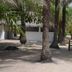 Oudja Hotel in Cap Skirring with palm trees and sandy outdoor seating area