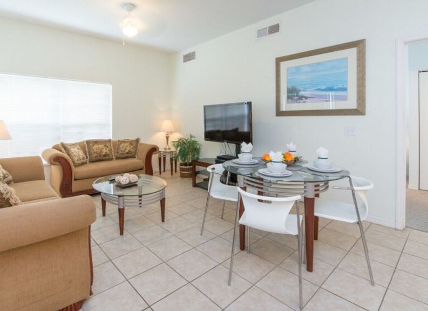Villas at Seven Dwarfs Lane Resort in Kissimmee living room with sofa, TV and dining table
