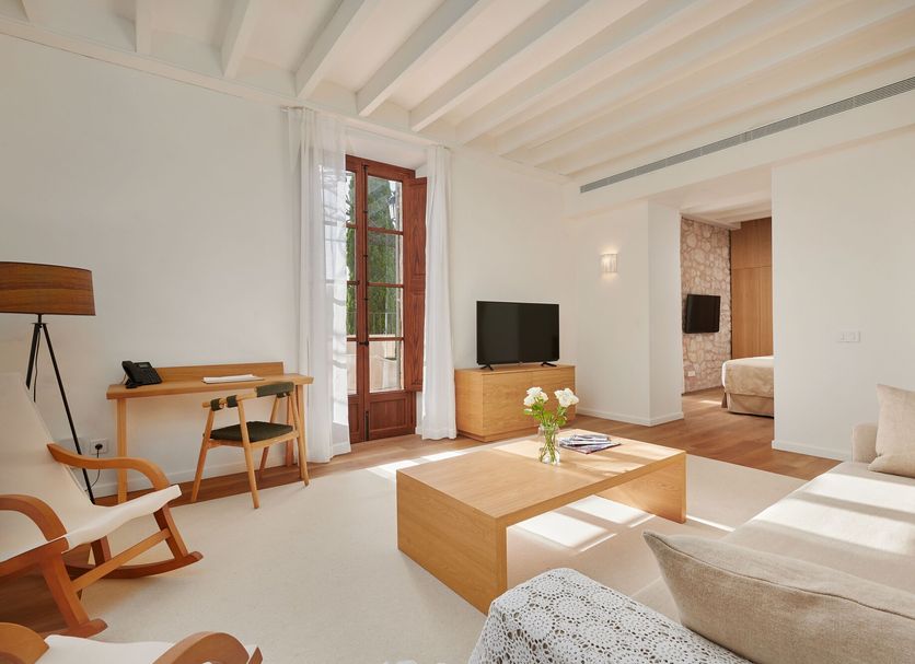 Es Figueral Nou Hotel Rural & Spa in Montuïri living room with sofa, coffee table, desk and TV