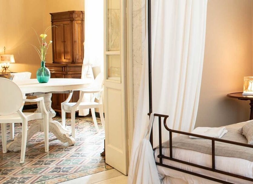 Villa Belverde Boutique Hotel in Marina di Carrara: wrought-iron canopy bed with sheer curtains and bedside lamp