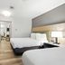 Country Inn & Suites by Radisson, Merrillville, IN guest room with two beds and bedside lamps