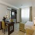 Intercity João Pessoa room with bed, desk, wall TV and large window in João Pessoa