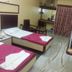 Hotel Rajmata Pvt Ltd in Hyderabad twin room with two single beds, TV, chair, and curtained window