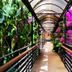 Çetinel Otel in Adana walkway with arched canopy, tropical plants, and bright pink flowers