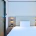 Hanting Nanshan Avenue Shenzhen guest room with a neatly made bed and bedside lamps
