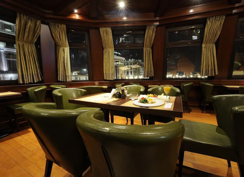 Hotel Senigallia Skopje lounge with table seating and city views through tall windows