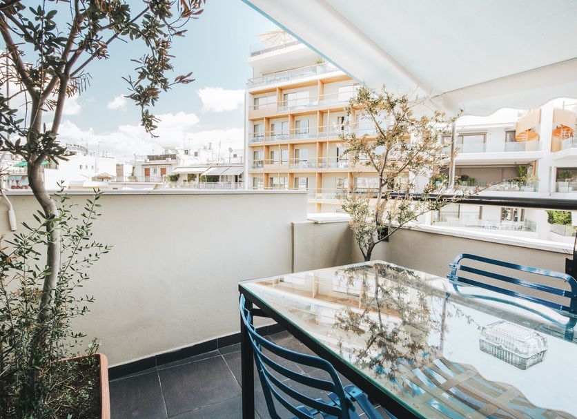 Athens Studios in Athens balcony with glass table, chairs, and city view