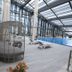 Vip Hotel Doha indoor pool with lounge chairs and a woven cabana under a glass roof