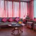 Hotel Tashi Delek in Gangtok lounge with carved wooden sofas, pink cushions and a central coffee table