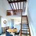 Résidence Les Cigales in Porto-Vecchio: loft-style hotel room with wooden stairs, mezzanine, and dining area