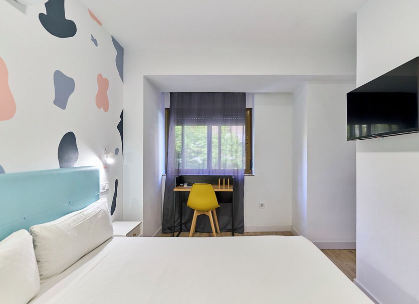 Hostal Carmen by gaiarooms room in Salamanca with double bed, desk by window, and wall-mounted TV