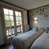 Chalet Appart'Hôtel l'Eau Vive room with twin beds, floral wall mural and balcony doors in Saint-Nicolas-la-Chapelle