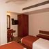 Hotel Maurya International, Chennai room with two single beds, red chairs and wardrobe