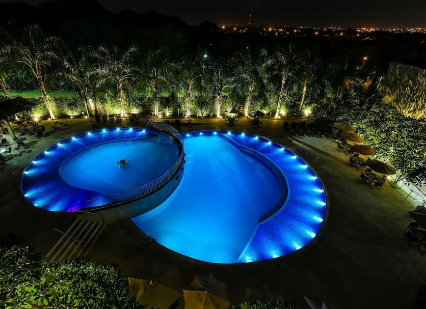 Viale Cataratas Hotel & Eventos in Foz do Iguaçu, illuminated outdoor pool at night with palm trees