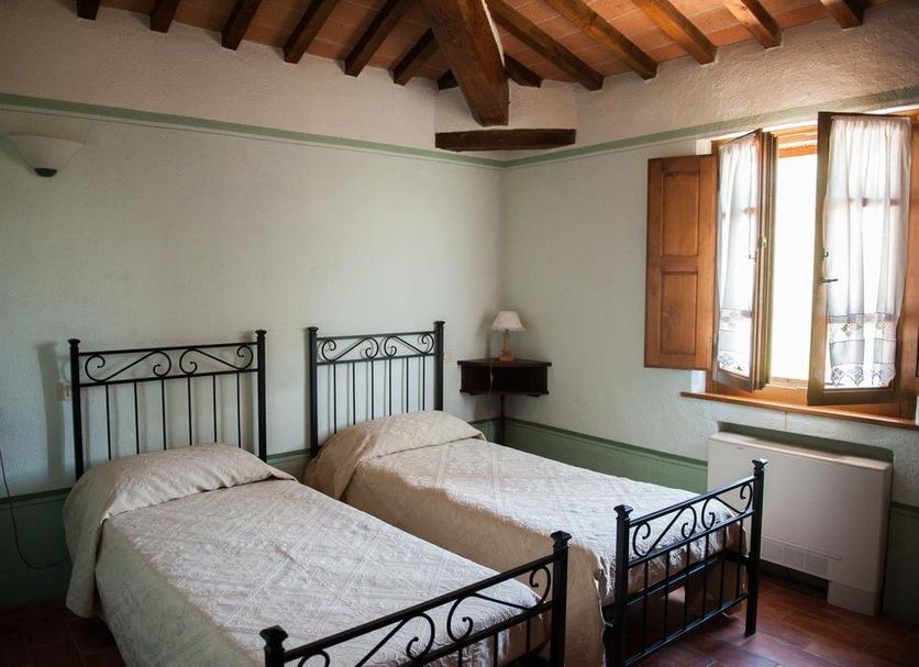 Agriturismo Villa La Morina in Cortona: twin beds in a rustic room with wood beams and an open window