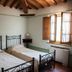 Agriturismo Villa La Morina in Cortona: twin beds in a rustic room with wood beams and an open window