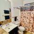 Lower Unit-Yosemite Woods-Inside Yosemite bathroom with sink, toilet, mirror and shower curtain in Yosemite West