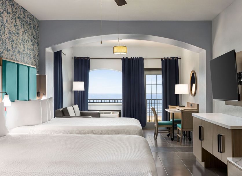 La Copa Inn Beach Hotel South Padre Island guest room with two beds, balcony ocean view, and desk