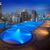 Shama Sukhumvit Bangkok rooftop pool in Bangkok with illuminated city skyline at dusk