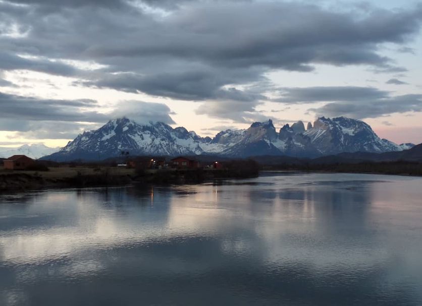 Hotel del Paine in Torres del Paine with mountain reflections over a calm lake at dusk