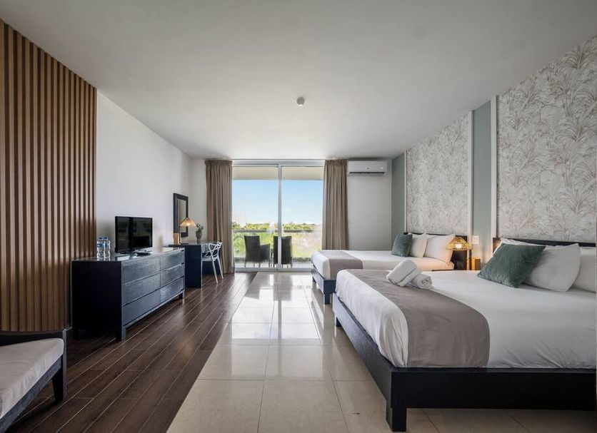 Playa Blanca Beach Resort in Río Hato room with two beds, balcony sea view and modern TV console