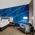 Comfort Inn & Suites Donna guest room with king bed, blue accent wall, and armchair