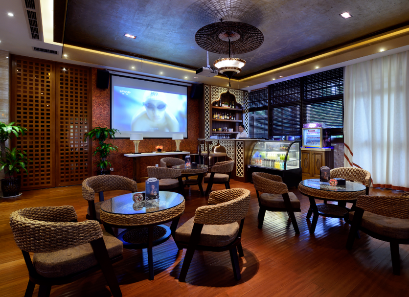 Greenpeak Thai Villas in Chengdu lounge with woven chairs, round tables, and a projection screen