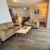 Caloundra Central Apartment Hotel living room with sofa, coffee table, TV and floor lamp in Caloundra