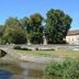Hotel Sonneck, Schwäbisch Hall: stone bridge over a calm river beside a grassy riverside park