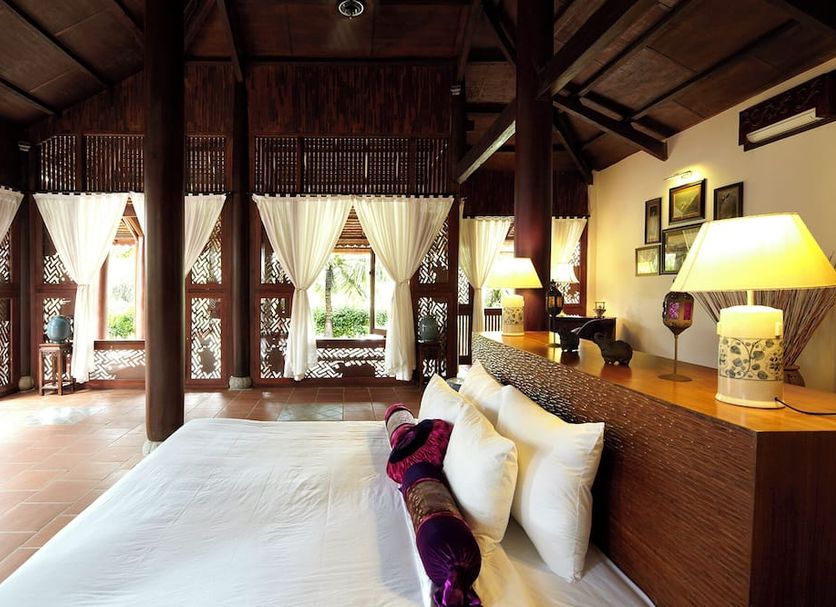 Ho Tram Beach Boutique Resort & Spa in Ba Ria: airy suite with king bed, wood beams and garden views