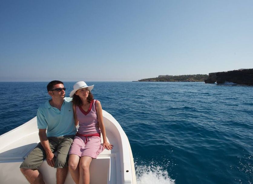 Oasis Scaleta Hotel in Skaleta: couple sitting on a boat with blue sea and coastline view