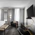 The Warrior Hotel, Autograph Collection in Sioux City guest room with king bed, chair, bench and wall-mounted TV