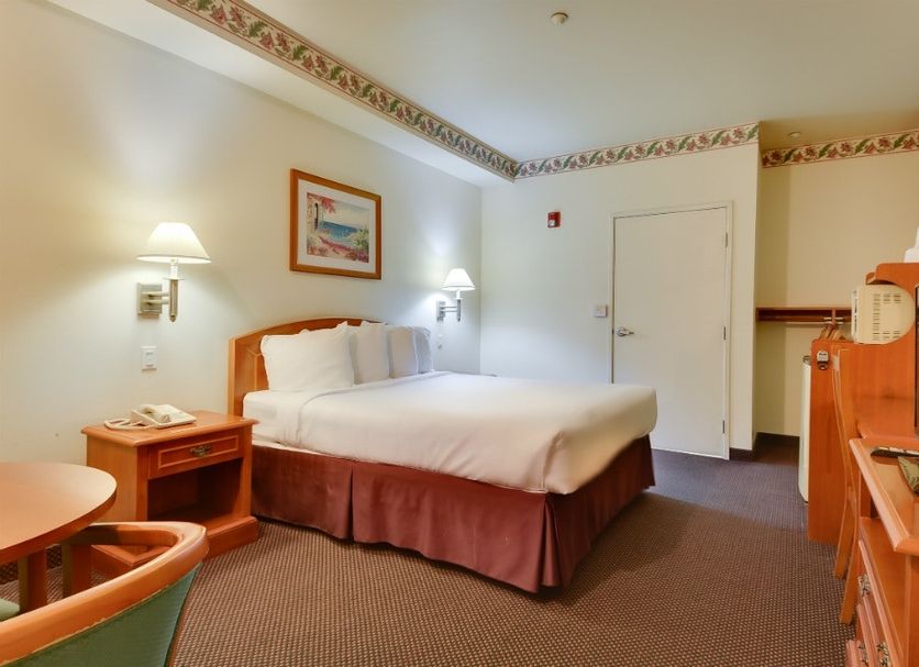 Vagabond Inn Hacienda Heights guest room with double bed, wall lamps, desk, and TV