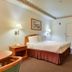 Vagabond Inn Hacienda Heights guest room with double bed, wall lamps, desk, and TV