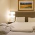 Residencial Lar do Areeiro in Lisbon, a neatly made double bed with bedside lamps and wall art