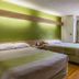 Motel 6 Charlotte University in Charlotte room with two beds and green accent wall